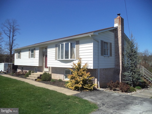 raised ranch featuring a front lawn