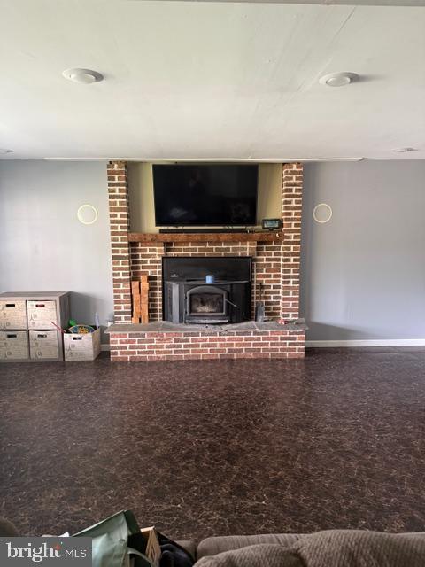65 Campbell Rd, York, PA 17402 - living area featuring speckle patterned floor, a brick fireplace, and baseboards