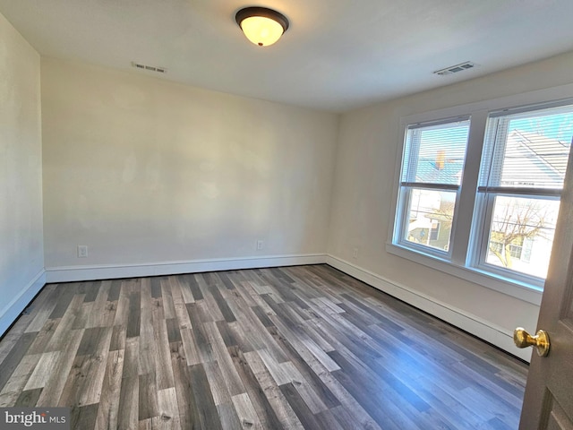 empty room with hardwood / wood-style flooring and plenty of natural light