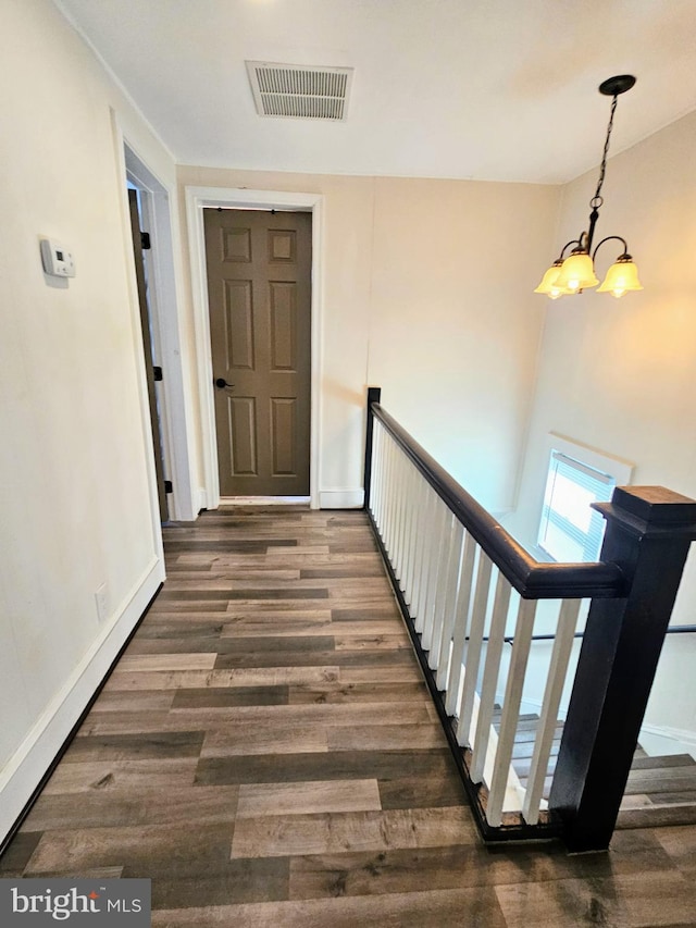 hallway featuring dark hardwood / wood-style flooring and a notable chandelier