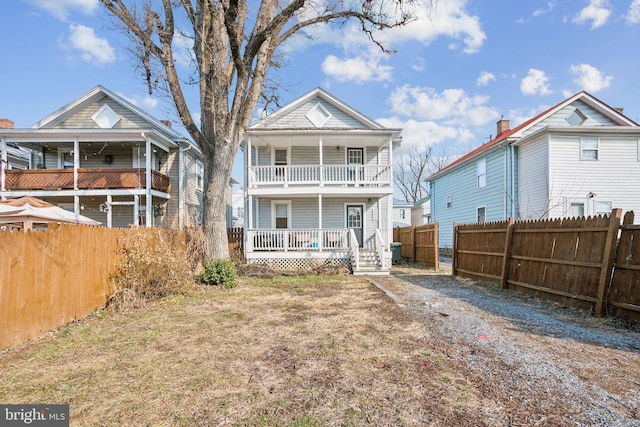 back of property featuring a porch and a balcony