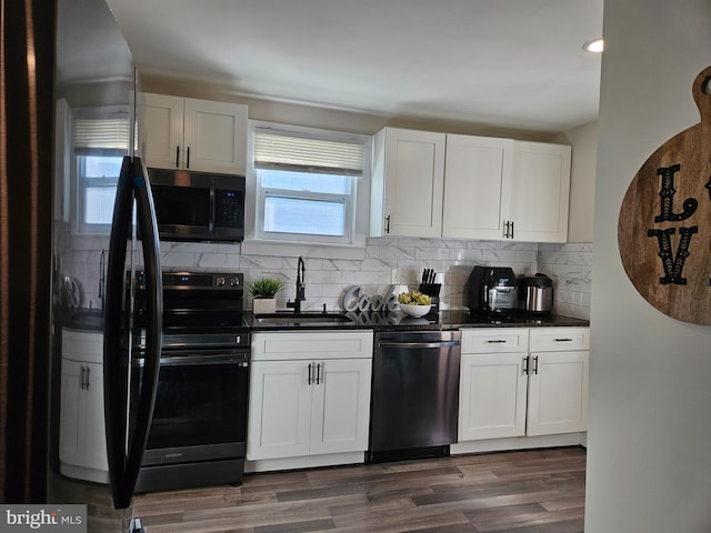 kitchen featuring dark hardwood / wood-style flooring, sink, appliances with stainless steel finishes, white cabinets, and decorative backsplash