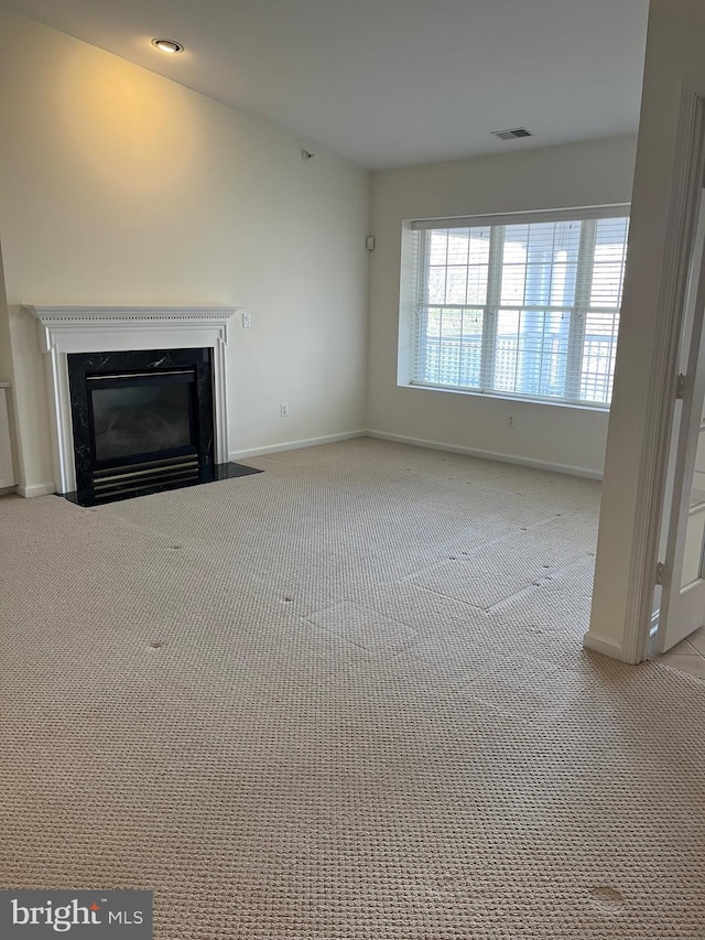 unfurnished living room featuring a fireplace and light colored carpet