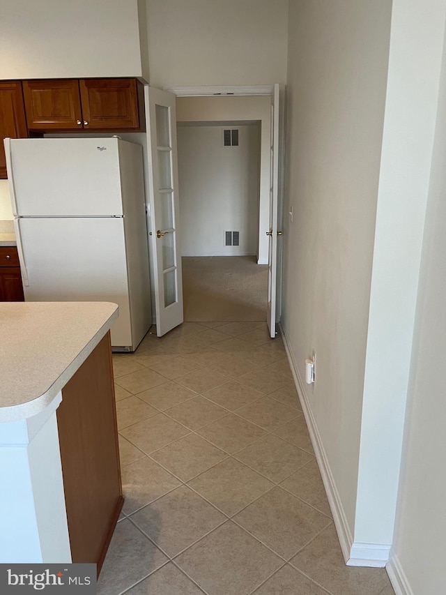 kitchen featuring white refrigerator and light tile patterned flooring