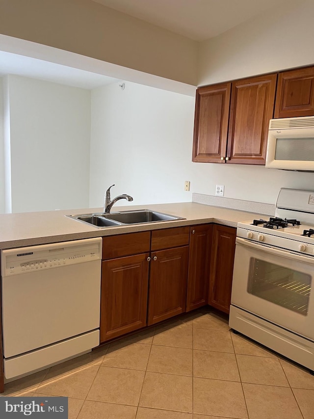 kitchen with sink, white appliances, kitchen peninsula, and light tile patterned flooring