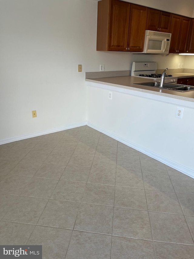 kitchen featuring stove, light tile patterned floors, and sink