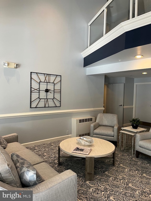 living room featuring a towering ceiling and radiator heating unit