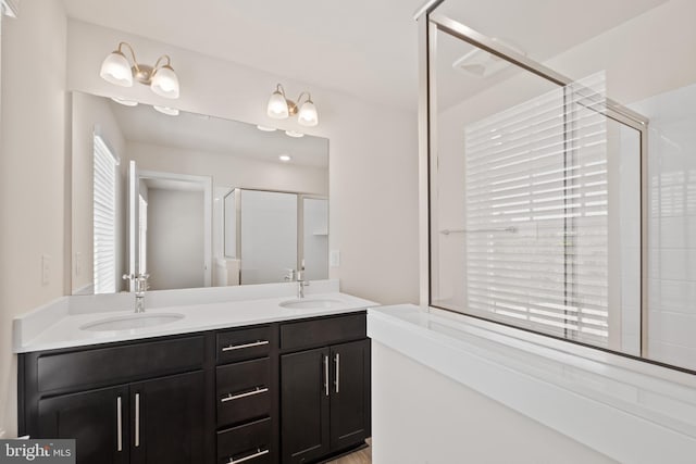 bathroom featuring vanity and a shower with door