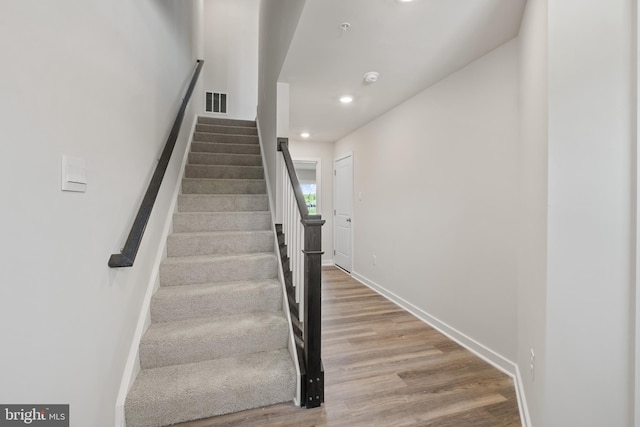 staircase with hardwood / wood-style flooring