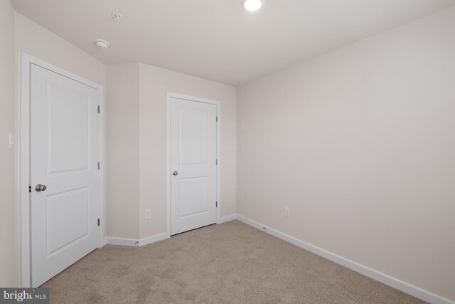 unfurnished bedroom with light colored carpet