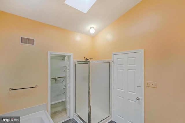 bathroom with vaulted ceiling with skylight and walk in shower