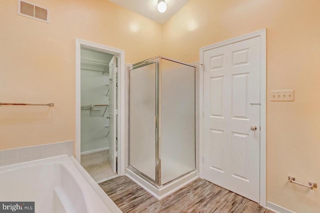 bathroom with hardwood / wood-style flooring and plus walk in shower