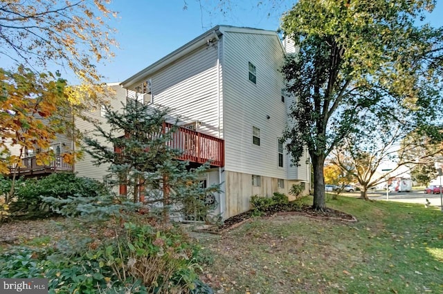 view of home's exterior featuring a wooden deck and a lawn