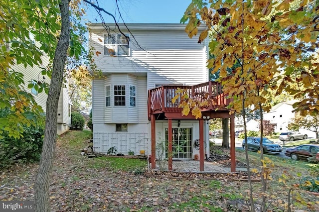 rear view of house featuring a wooden deck