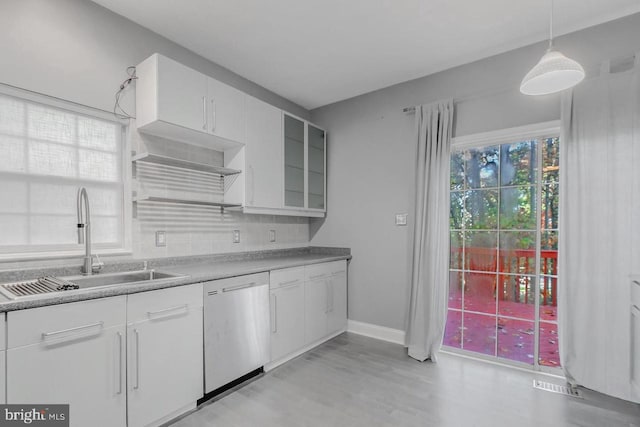 kitchen with pendant lighting, sink, stainless steel dishwasher, and white cabinets