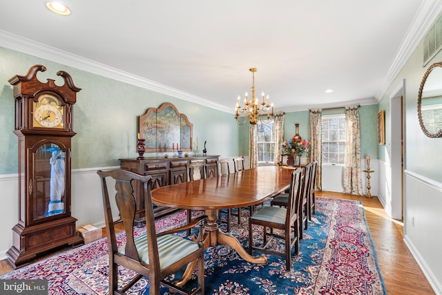 dining space with light wood-style flooring, recessed lighting, crown molding, baseboards, and an inviting chandelier