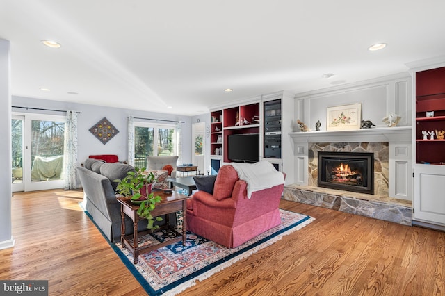 living area featuring light wood-style floors, recessed lighting, and a fireplace