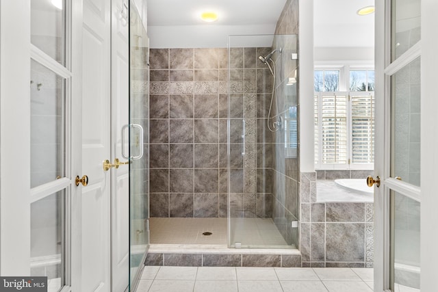 full bathroom with tile patterned flooring, a shower stall, and a bath