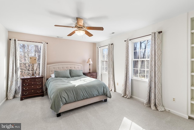 bedroom with light colored carpet, visible vents, ceiling fan, and baseboards