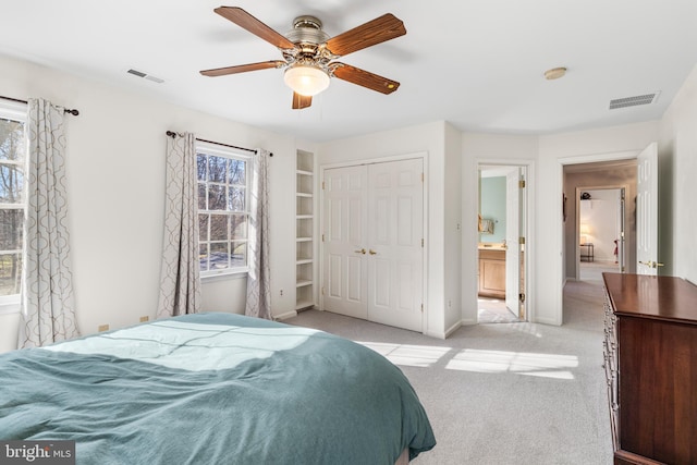 bedroom with a closet, visible vents, light carpet, and baseboards