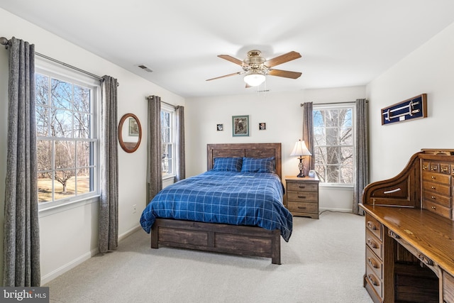 bedroom with a ceiling fan, light colored carpet, visible vents, and baseboards