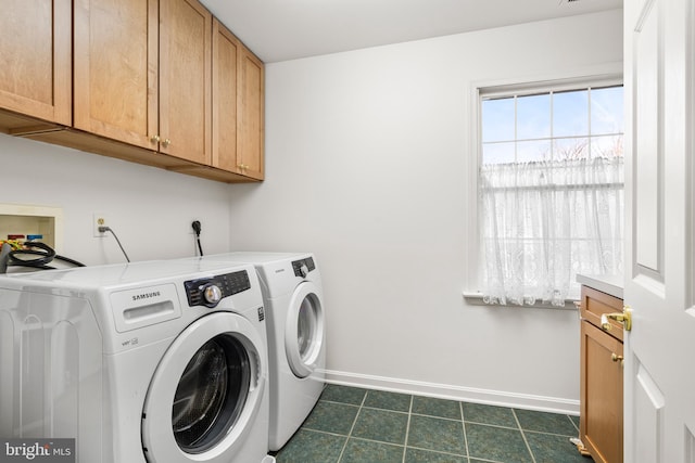 clothes washing area featuring washer and dryer, cabinet space, baseboards, and dark tile patterned flooring