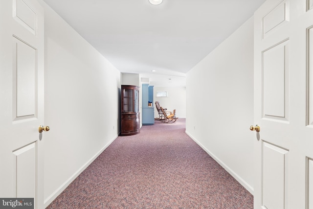 hallway with baseboards and carpet flooring