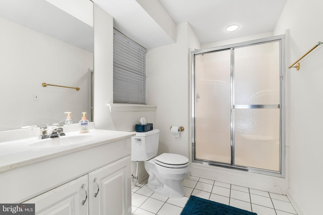 bathroom with toilet, a shower stall, vanity, and tile patterned floors