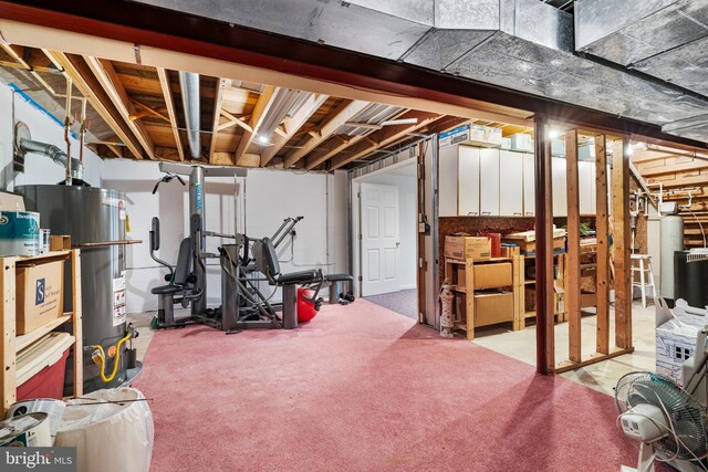 unfinished below grade area featuring light colored carpet and water heater