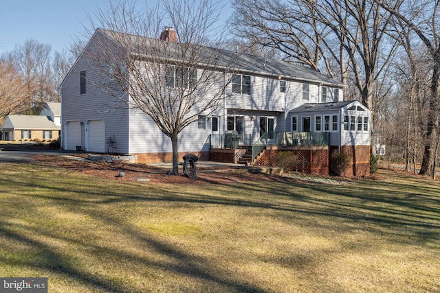 back of house featuring a garage, a chimney, a wooden deck, and a lawn