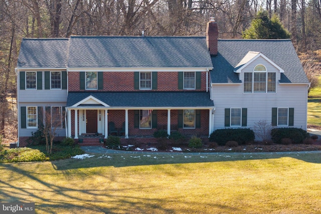 view of front of property with a shingled roof, a chimney, and a front lawn