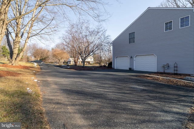 view of side of property featuring driveway and an attached garage