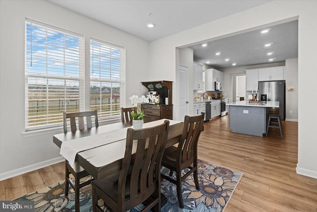 dining room with sink and light wood-type flooring