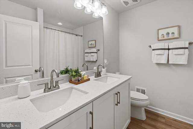 bathroom featuring vanity, wood-type flooring, and toilet