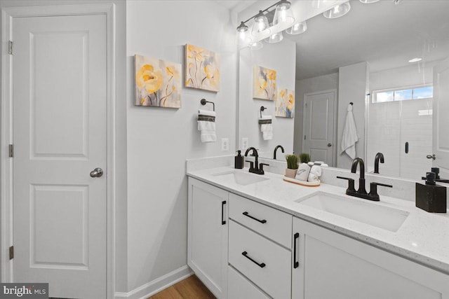 bathroom with vanity, a shower with door, and hardwood / wood-style floors