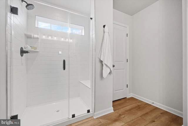 bathroom featuring a shower with shower door and hardwood / wood-style floors