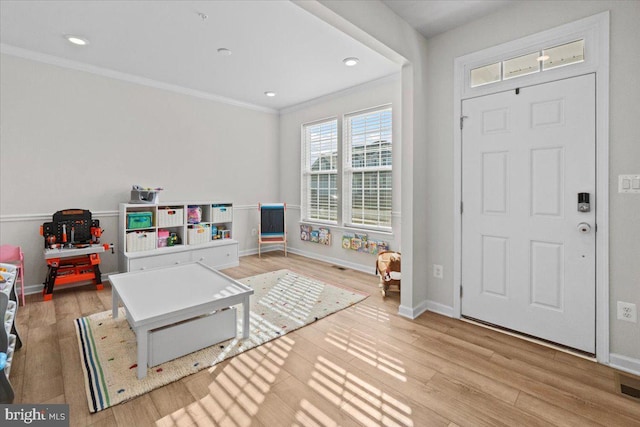 rec room featuring ornamental molding and light hardwood / wood-style floors