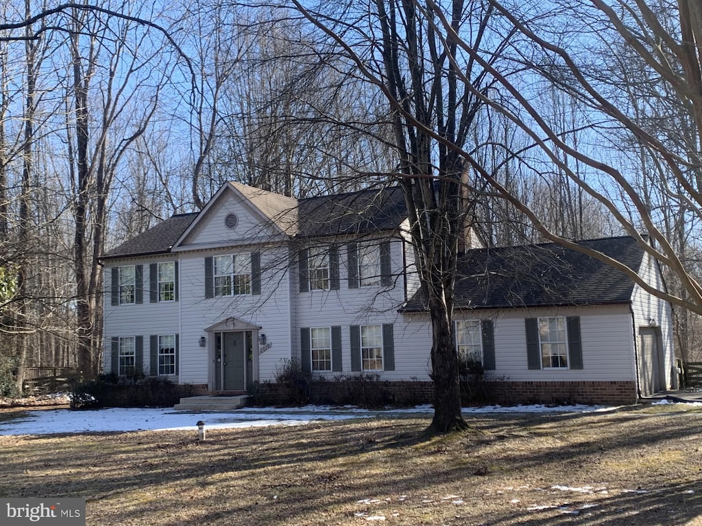 colonial home featuring a shingled roof