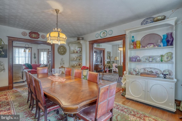 dining room with light hardwood / wood-style flooring and a textured ceiling