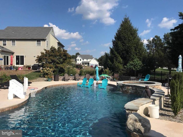 view of swimming pool featuring an in ground hot tub and a patio area