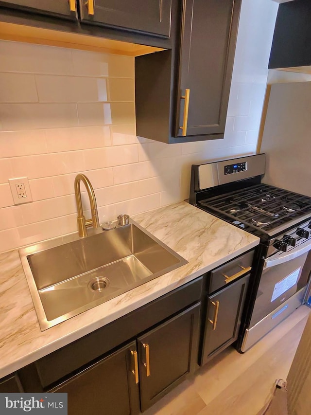 kitchen with tasteful backsplash, sink, and stainless steel gas stove