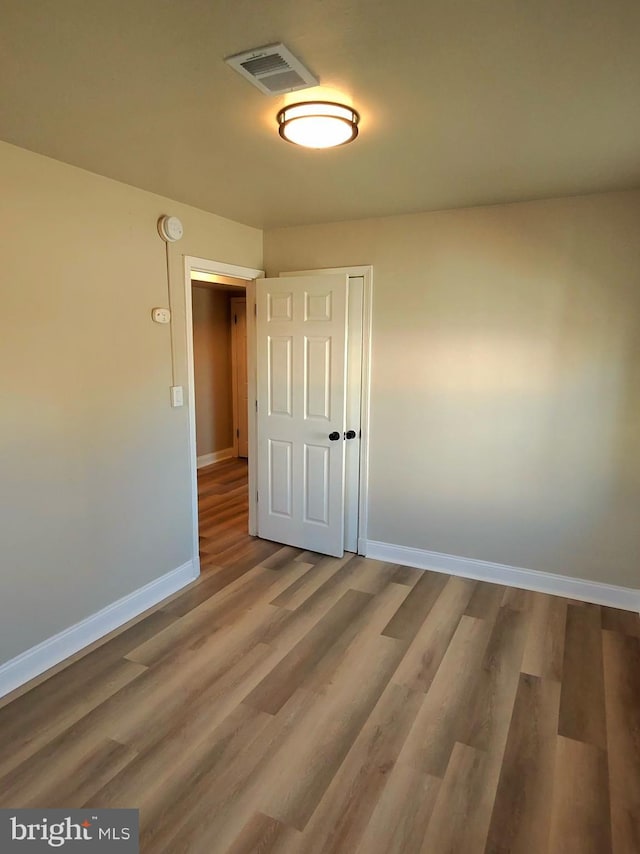 spare room with wood-type flooring