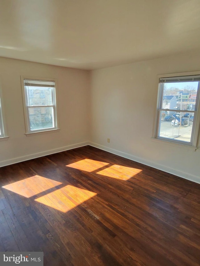 unfurnished room with dark wood-type flooring