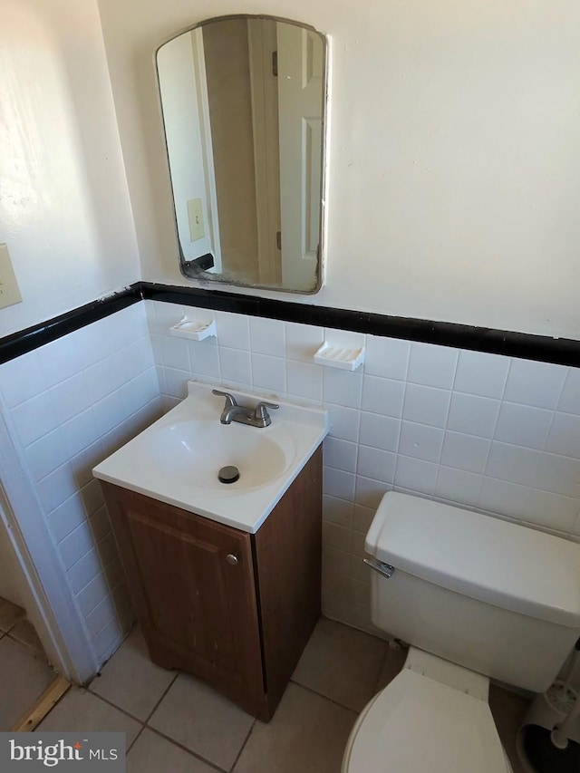 bathroom featuring vanity, tile patterned floors, tile walls, and toilet