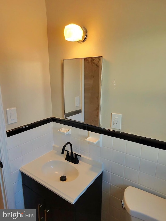 bathroom with vanity, tile walls, and toilet