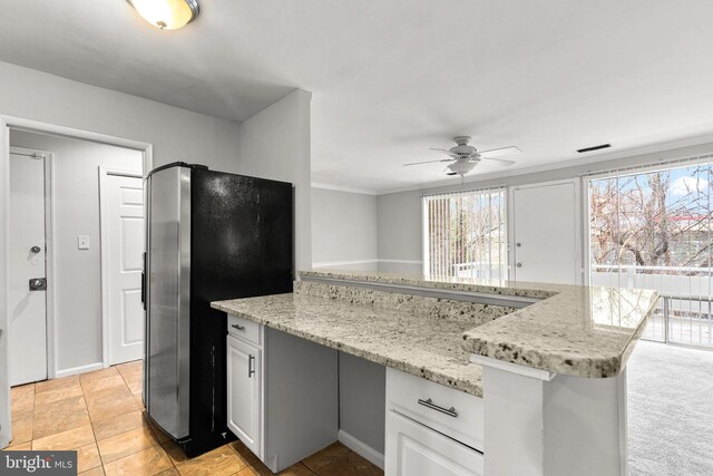 574 Wilson Bridge Dr Unit D-2, Oxon Hill, MD 20745 - kitchen featuring stainless steel refrigerator, white cabinets, ornamental molding, ceiling fan, and light stone countertops
