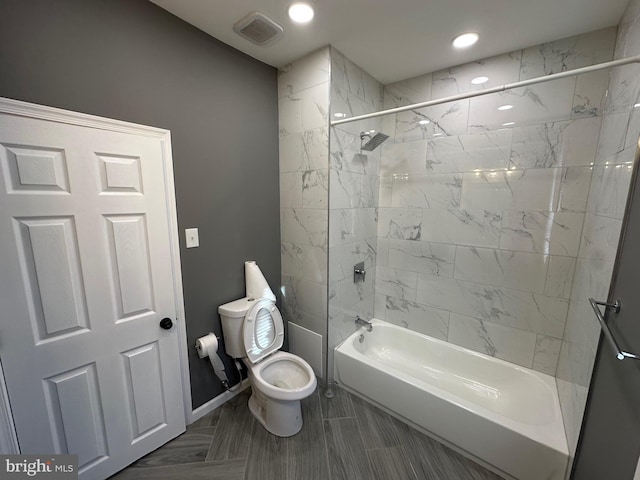 bathroom with tiled shower / bath combo and toilet