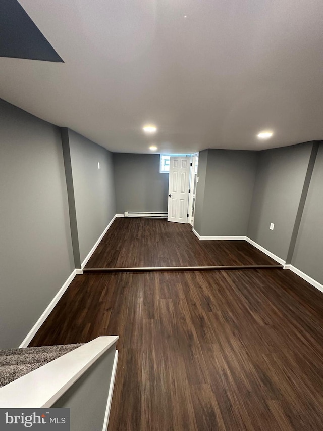 basement featuring hardwood / wood-style flooring and a baseboard radiator