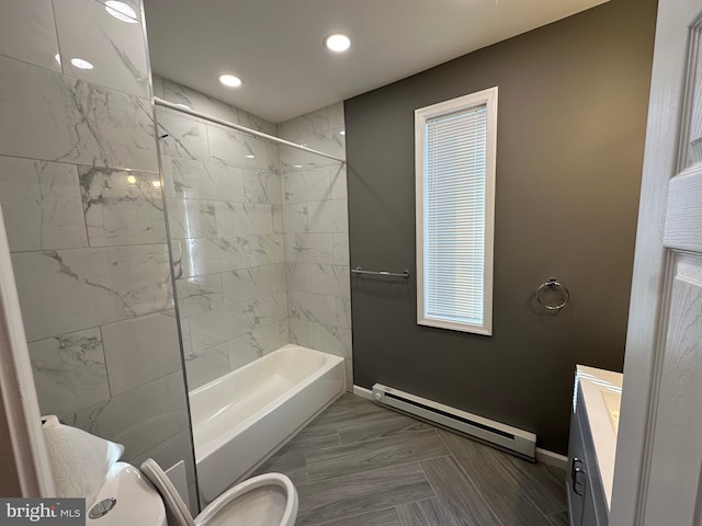 full bathroom featuring tiled shower / bath, a baseboard heating unit, vanity, and toilet