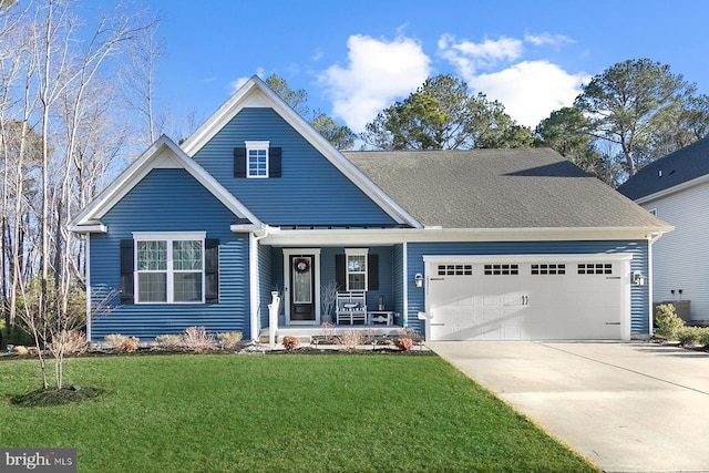 view of front of home featuring a garage, a front lawn, and covered porch